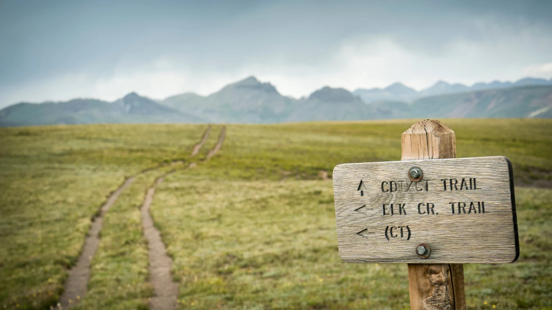 Continental divide trail sign and mountain range