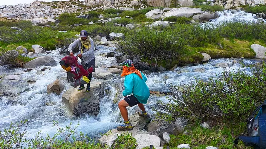 Muir Pass, Sierra Nevada California Hikers working together to cross a high run stream near Muir Pass on John Muir Trail.