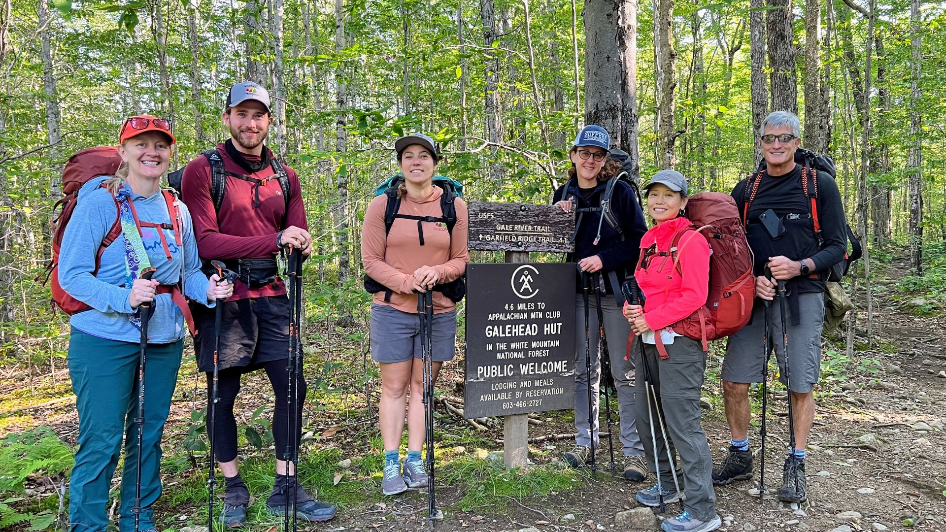 Hikers stand next to a sign for the Appalachian Trail in the White Mountains of New Hampshire