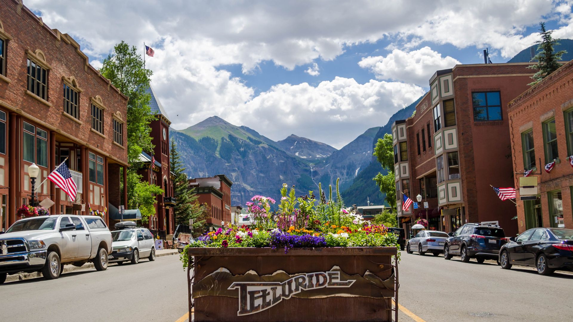 The town of Telluride's Main Street is lined with flowers and shops as it leads toward the mountains