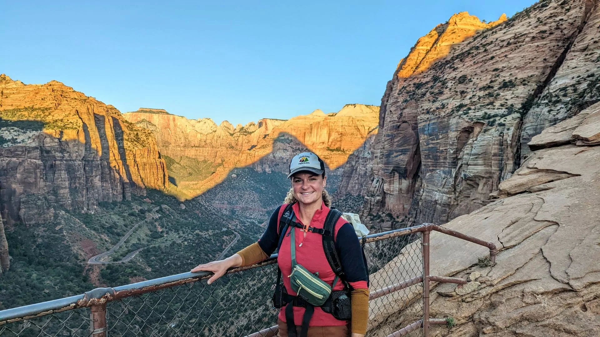 A Wildland Trekking guide stands at the Canyon Overlook trail as sunset turns the valley below orange