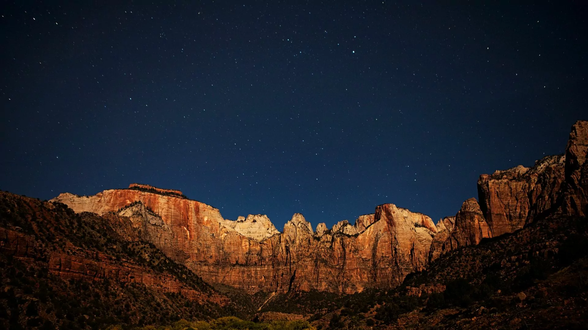 Stars shine brightly in the dark night sky at Zion National Park