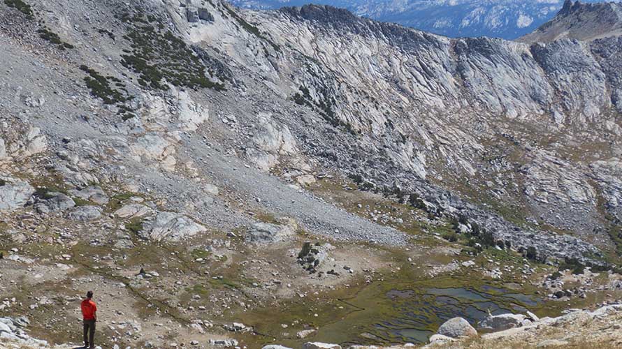 Lone hiker standing in front of alpine peaks in California