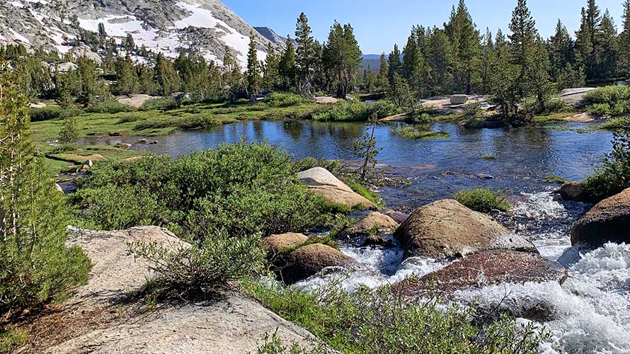 Crystal clear stream entering mountain lake in the Sierra Nevada Mountains of California