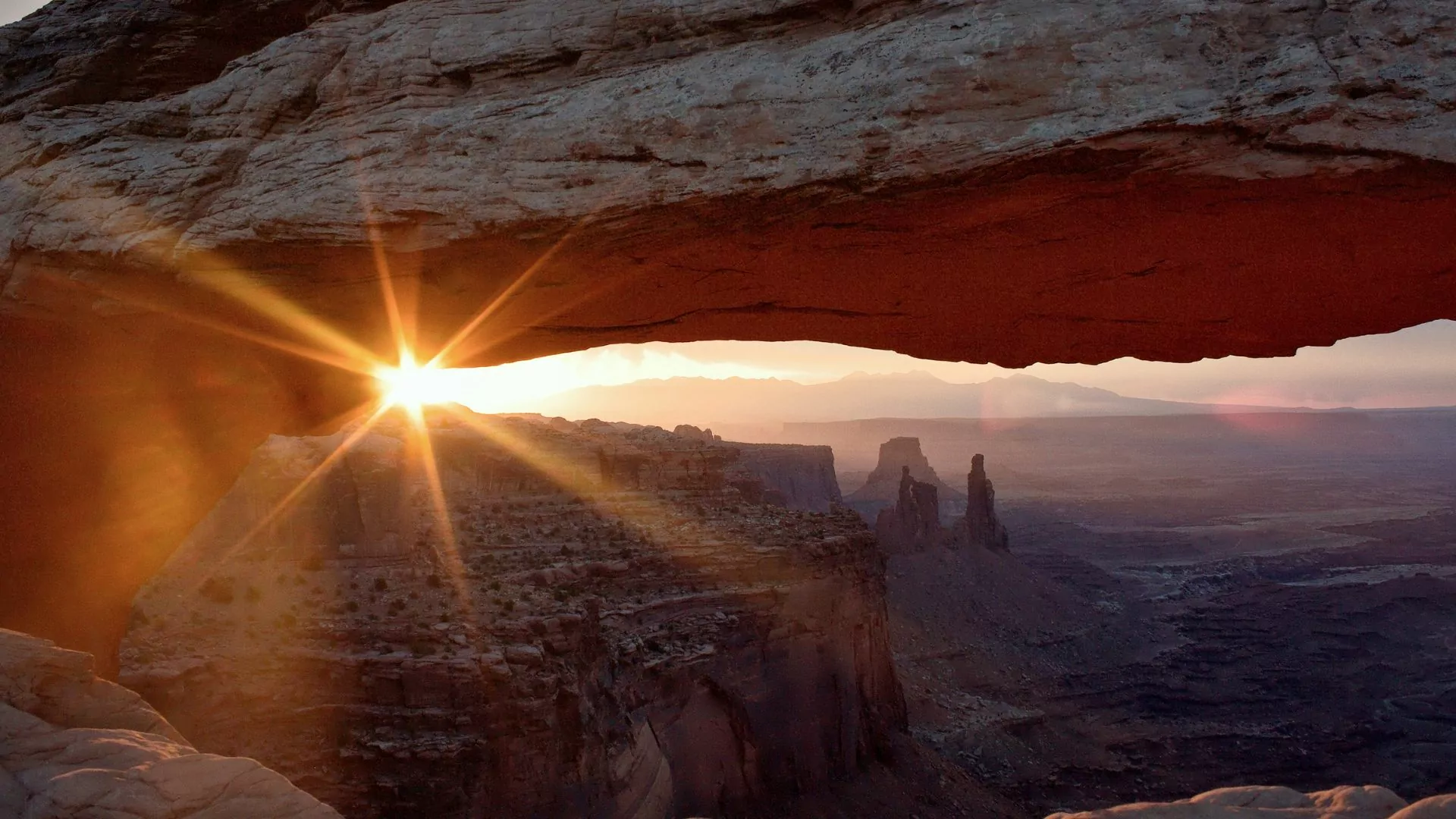 The sun sets through Mesa Arch in Canyonlands National Park Island in the Sky district