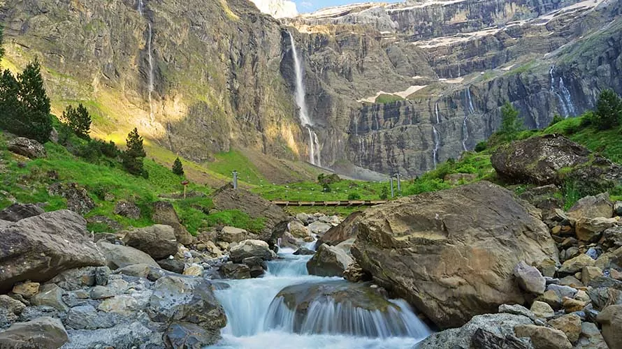 Cirque de Gavarnie beautiful waterfall with river underneath high cliffs, Pyrenees Mountains, France