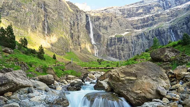 Cirque de Gavarnie beautiful waterfall with river underneath high cliffs, Pyrenees Mountains, France