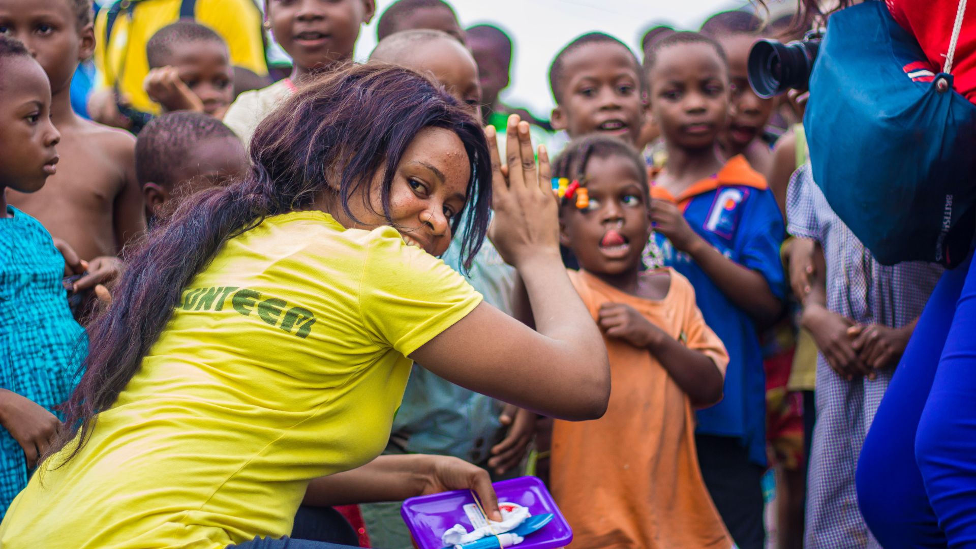 A visiting volunteer greets a group of local children