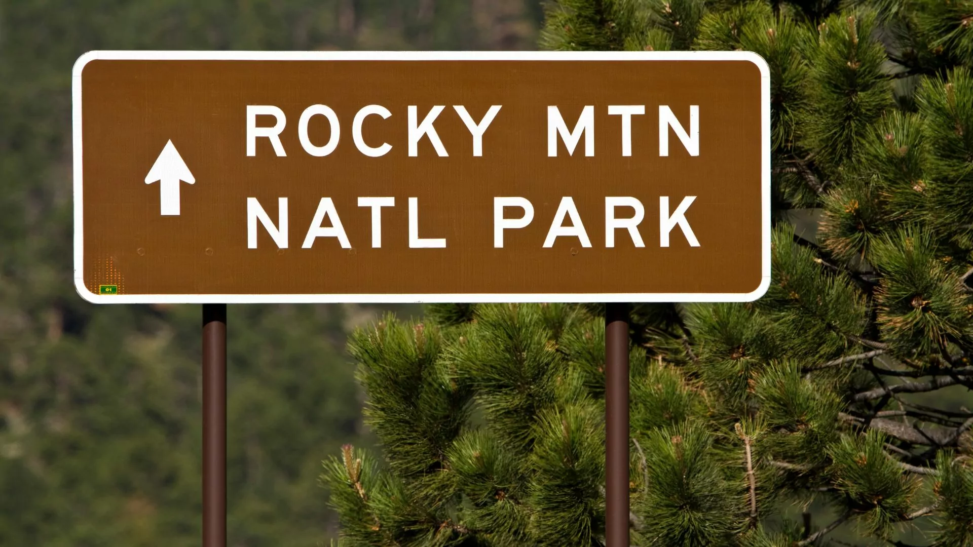 A highway sign points toward Rocky Mountain National Park