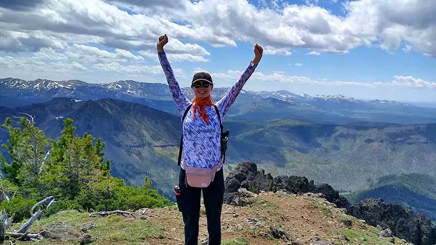 Woman standing on high ridge in Wyoming celebrating hike