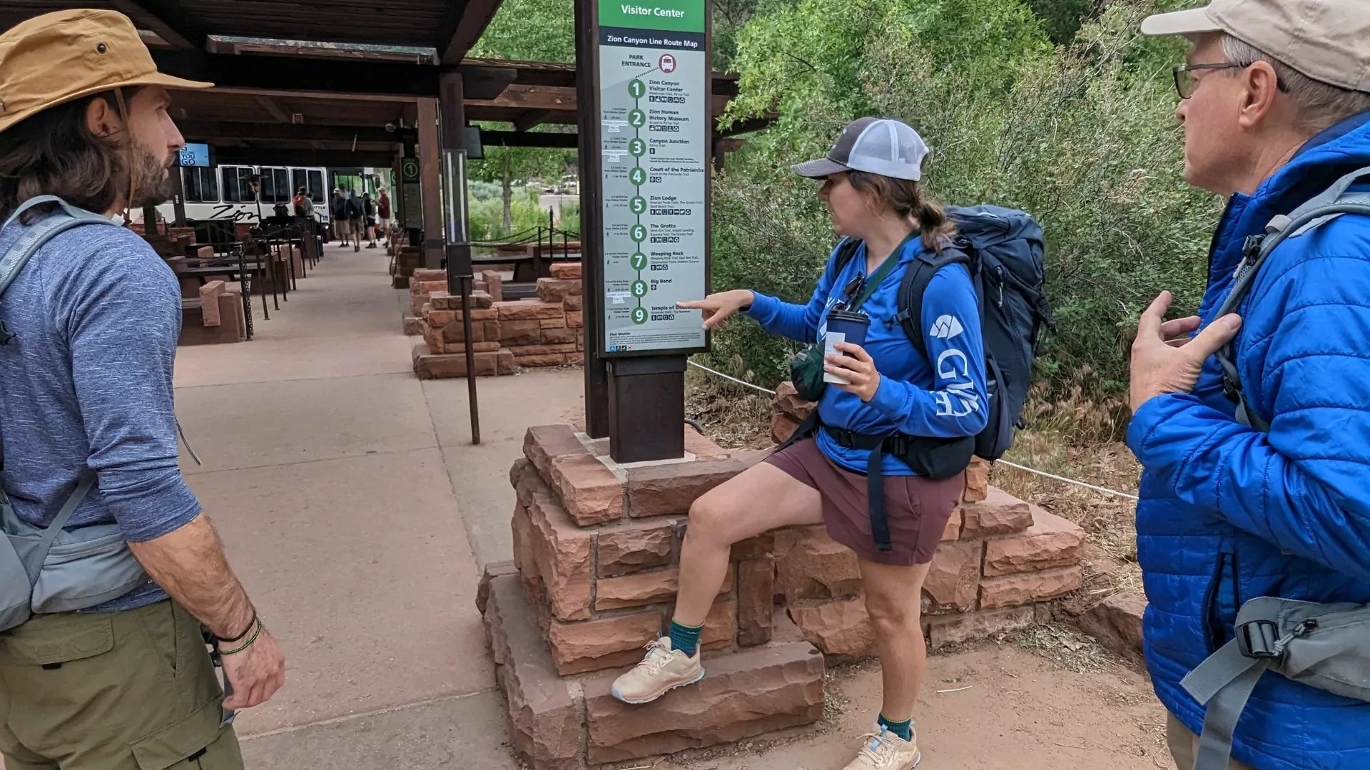 a day hike guide points out shuttle stops to her guests in Zion