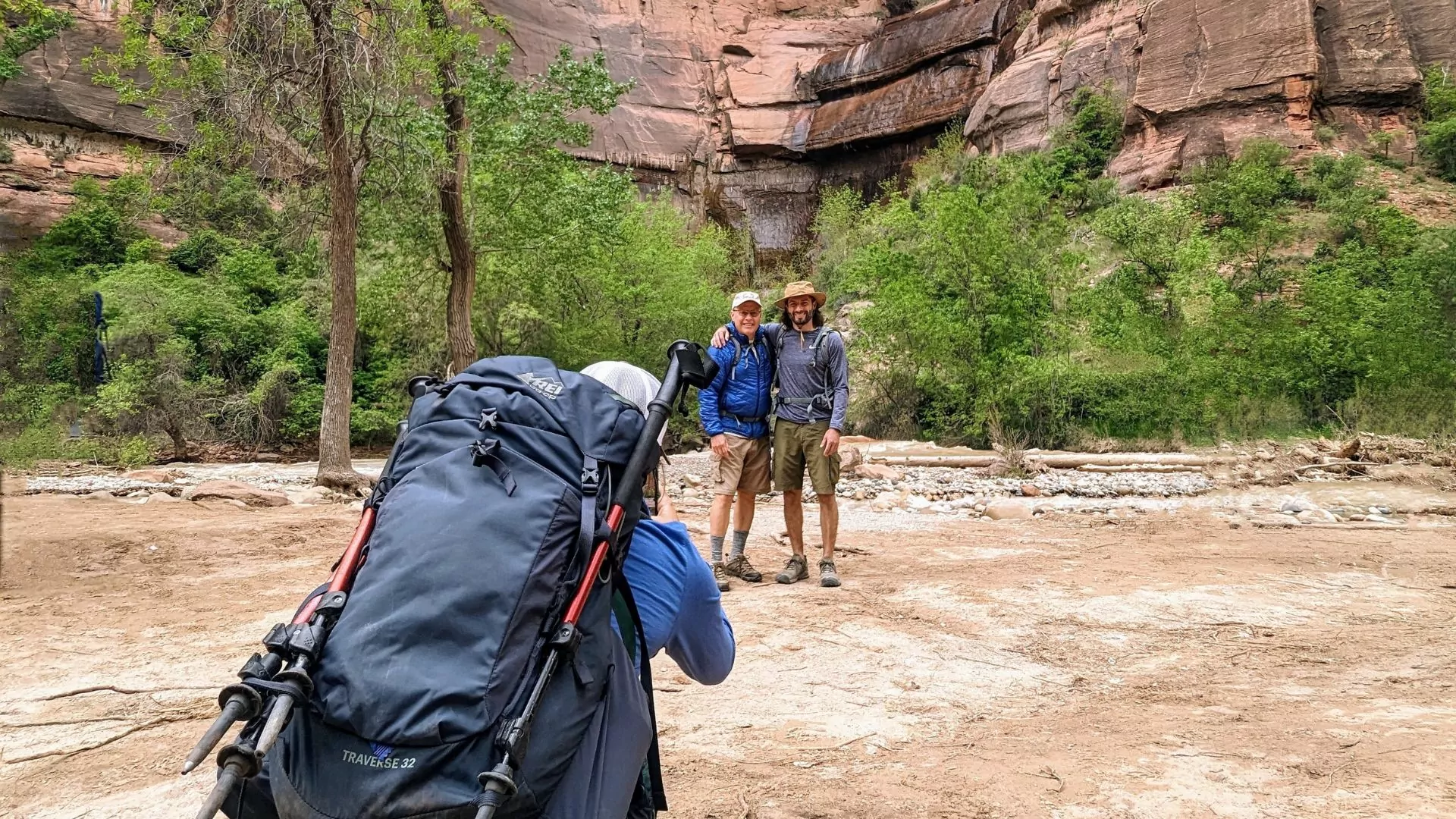 a guide takes a photo of her guests at a waterfall in zion