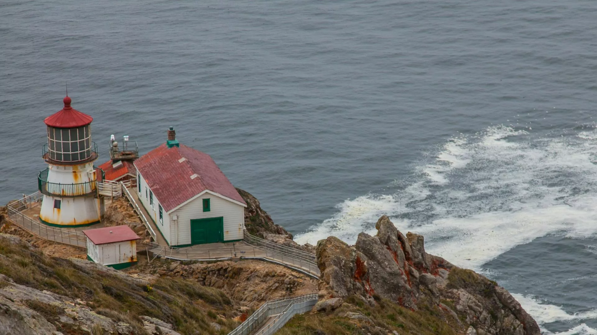 A light house perches on a rocky headland along Point Reyes National Seashore