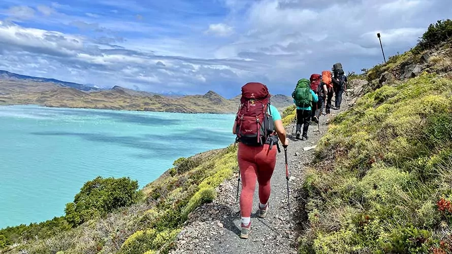 Hikers with turquoise lake in the background in Torres del Paine National Park, Chile