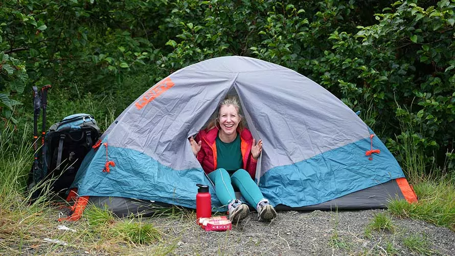 Woman hiker smiling from her tent on the Kenai Peninsula, Alaska