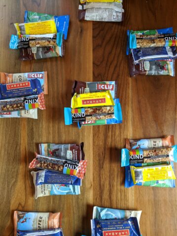 Hiking snacks are laid out in piles on a table