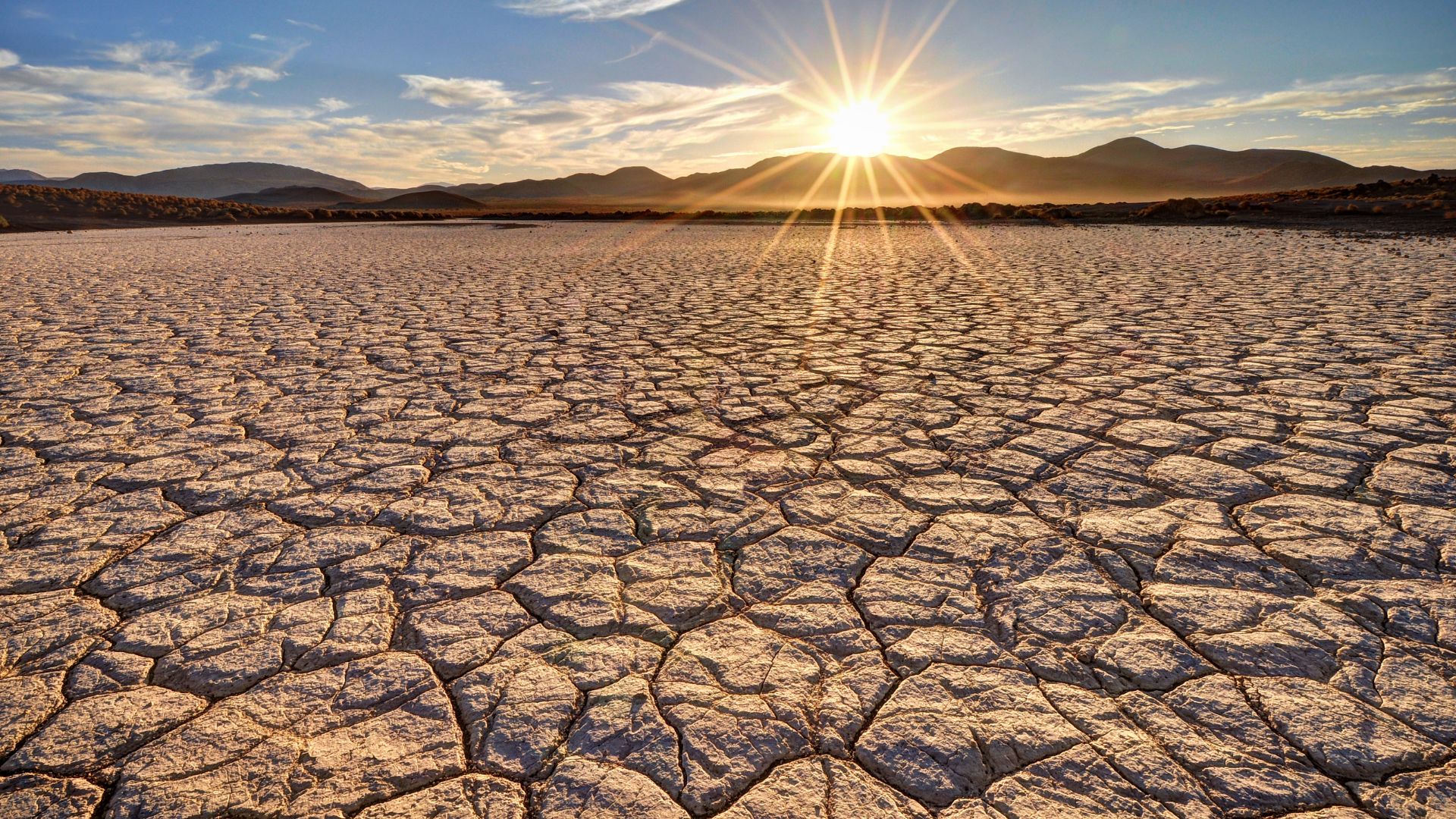 A sun baked expanse of dry mojave desert stretches to the horizon