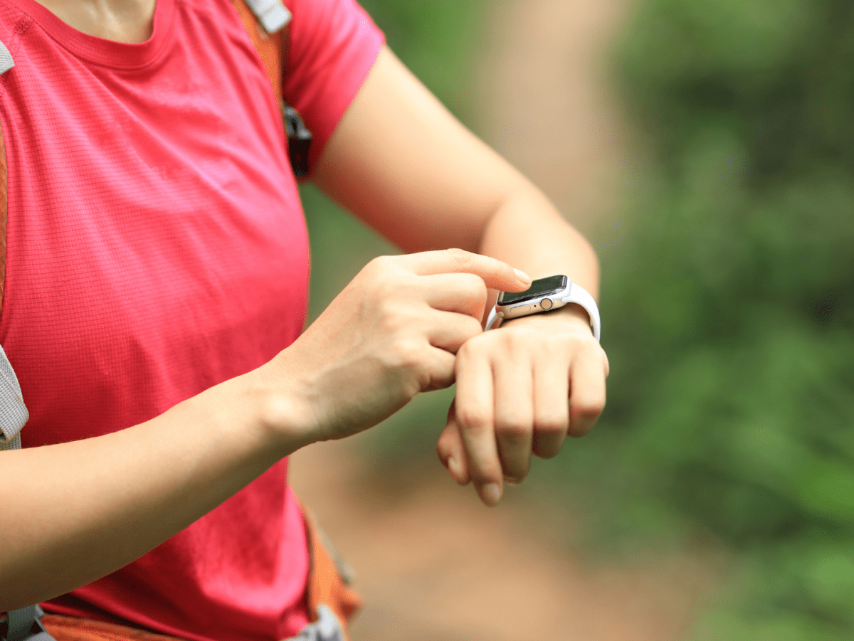 A hiker checks her smartwatch before hitting the trail