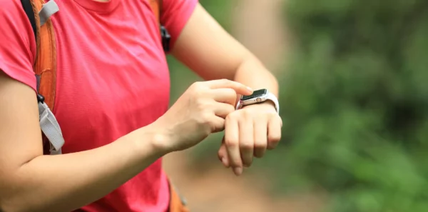 A hiker checks her smartwatch before hitting the trail