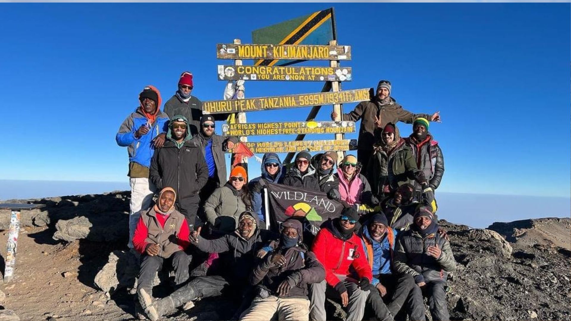 A group poses on the summit of Mount Kilimanjaro in Africa