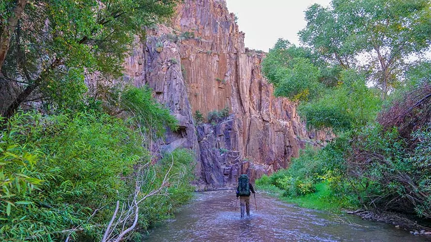 Backpacker walking in Aravaipa Creek, Arizona