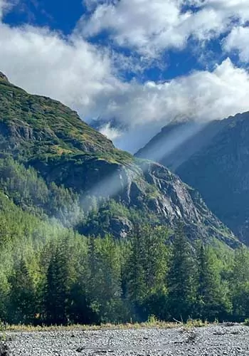Sun rays breaking through clouds on the Crow Pass Trail, AK