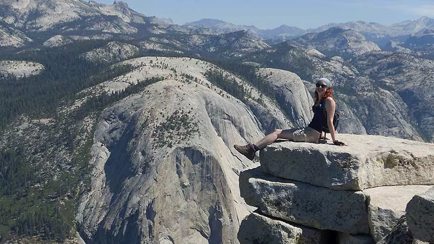 Woman sitting at the edge of Half Dome, Yosemite