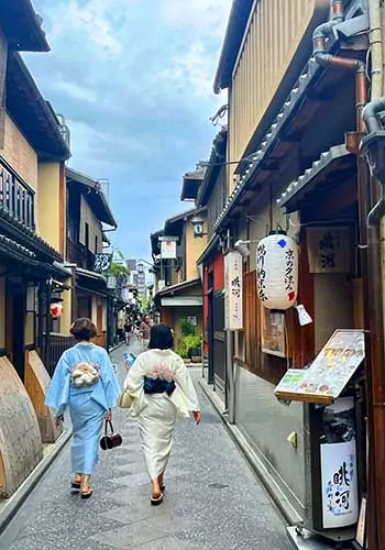 Two Japanese women walking in traditional attire in Kyoto