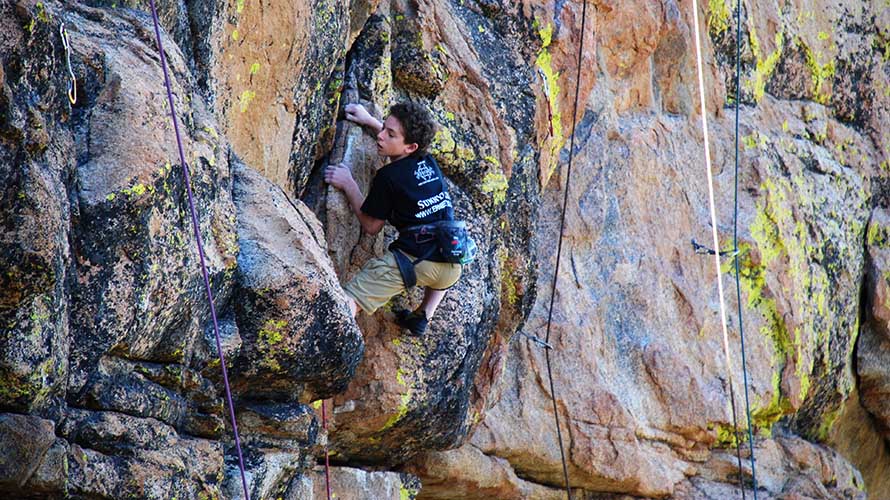 Young man rock climbing on beautiful granite, California