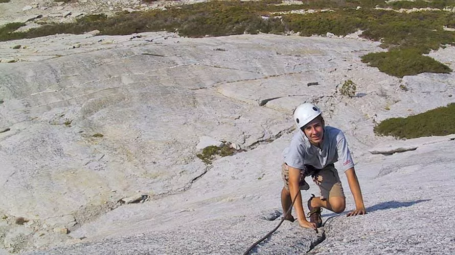 Rock climbing client ascending a slab on Fresno Dome, California