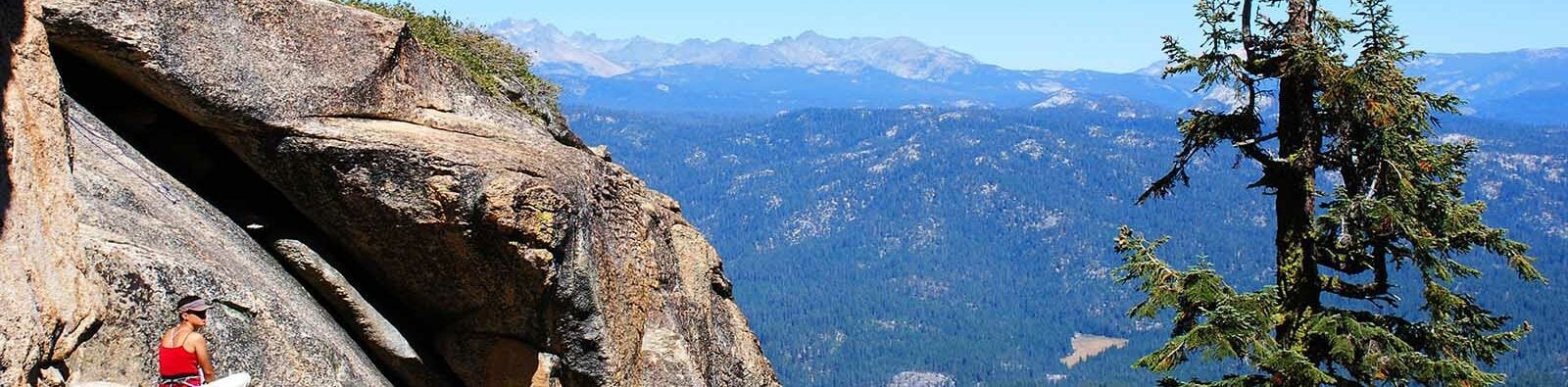 Woman climber sitting at Fresno Dome overlooking the Sierra Nevada Mountains