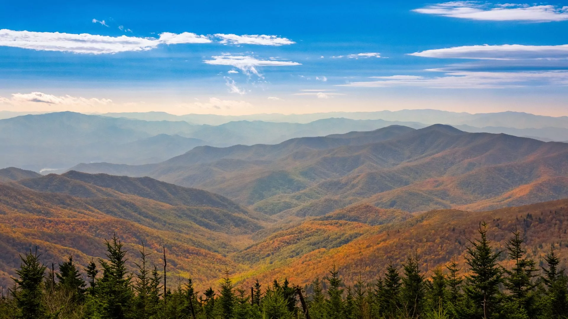 The smoky mountains stretch into the distance in colorful reds and oranges