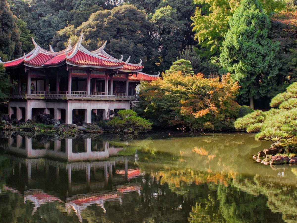 A traditional japanese building sits by the water in a tokyo park
