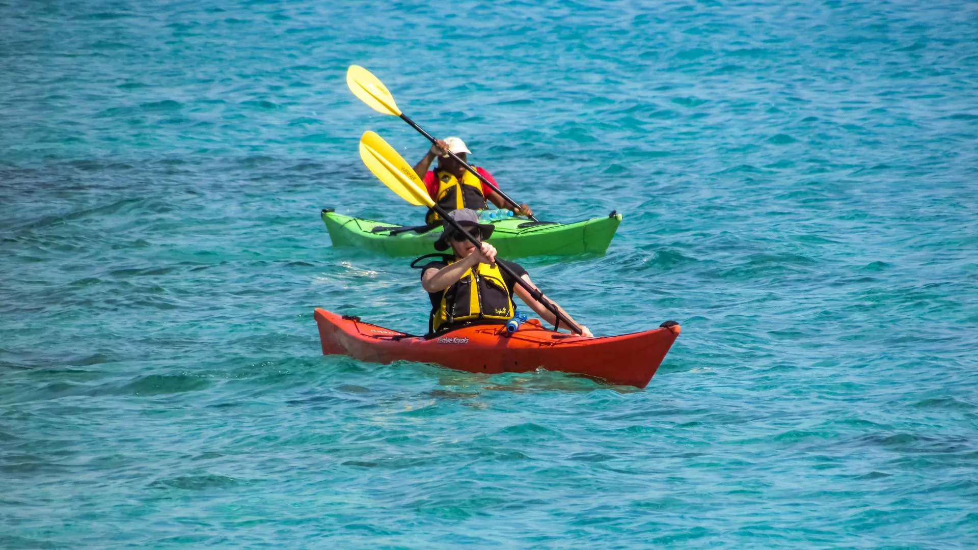 Kayakers paddle in tandem