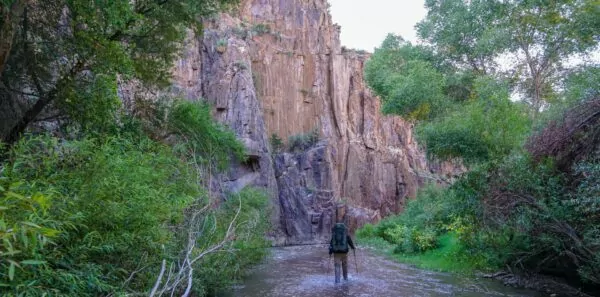 A backpacker hikes through Aravaipa Canyon