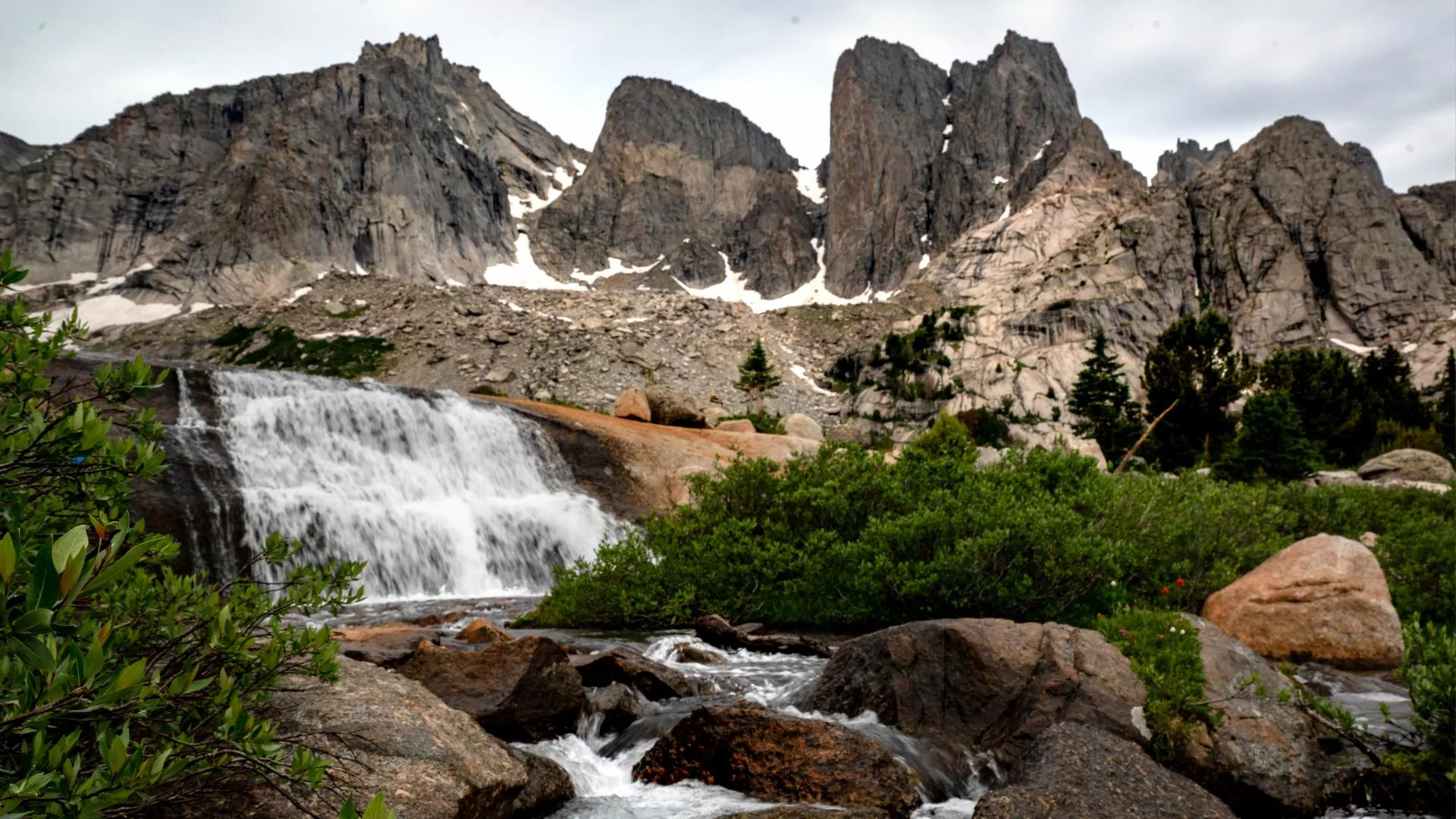 The cirque of the towers rises behind a small stream and waterfall