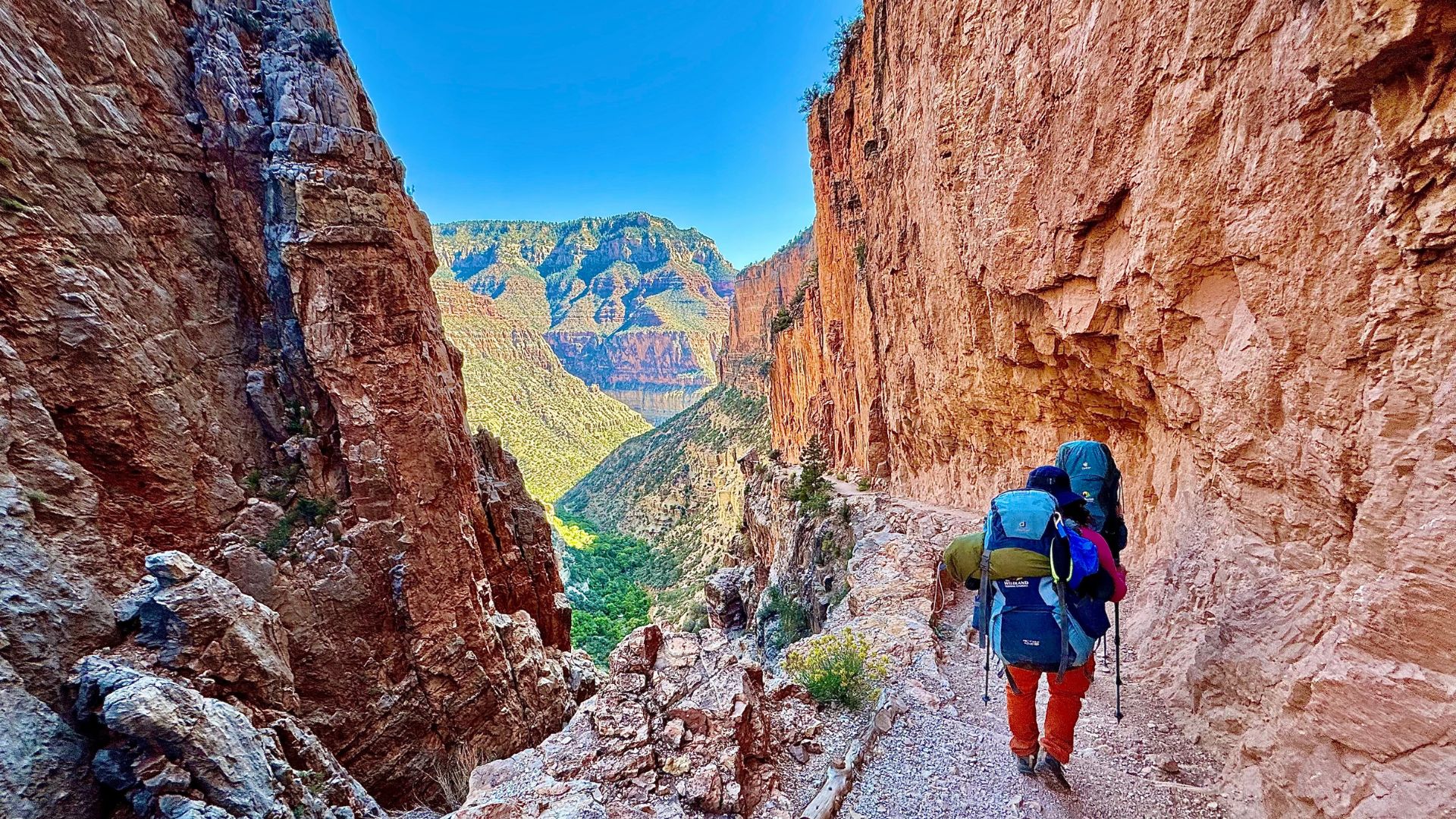 A backpacker descends a trail into the Grand Canyon