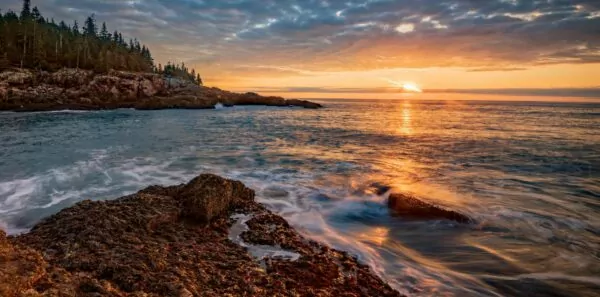The sun sets over the atlantic ocean at Acadia National Park