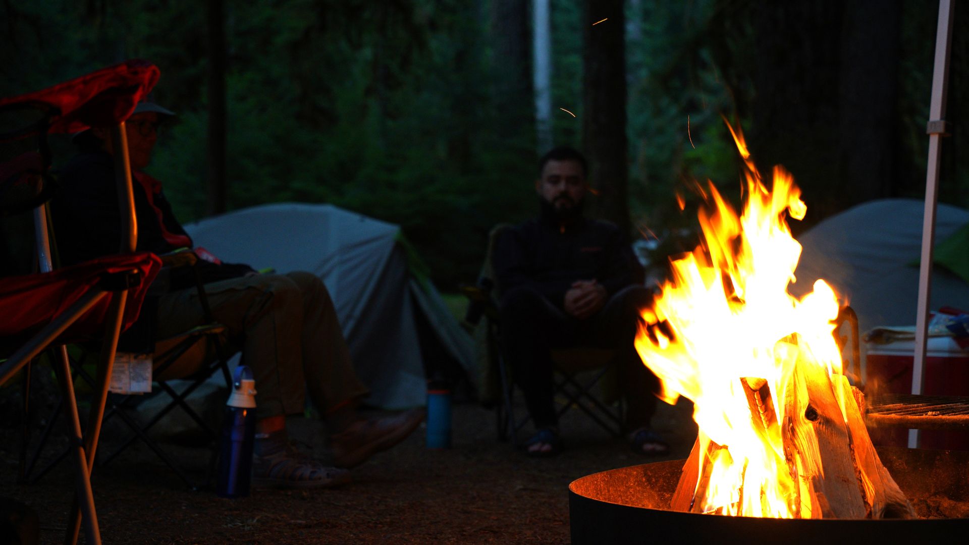 A campfire blazes in the darkness