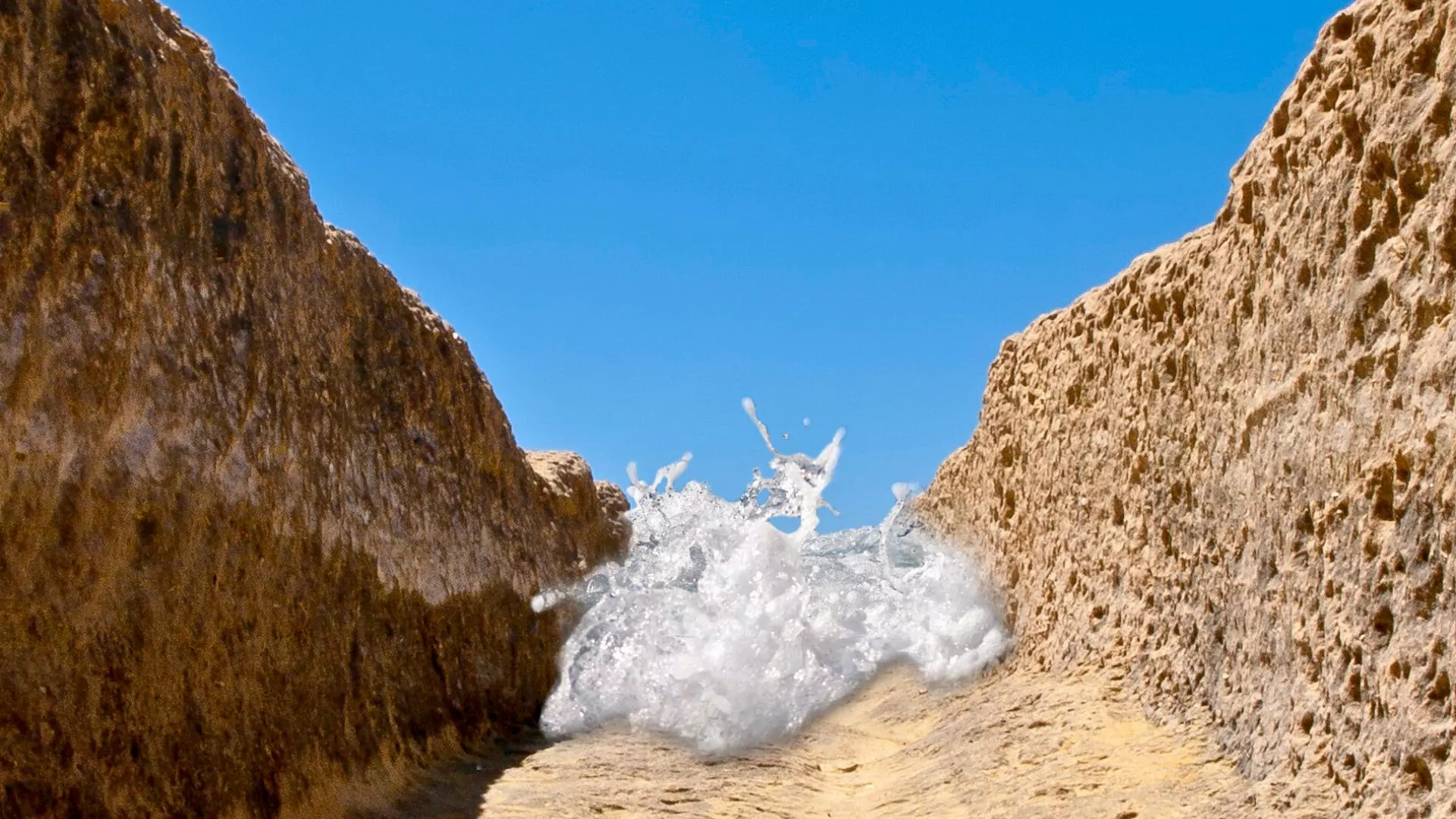 A wave of water rushes between canyon walls