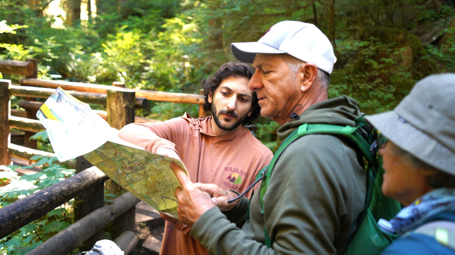 Three people look at a map outdoors