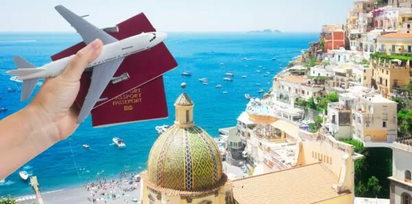 A traveler holds up a passport in front of an exotic seaside location
