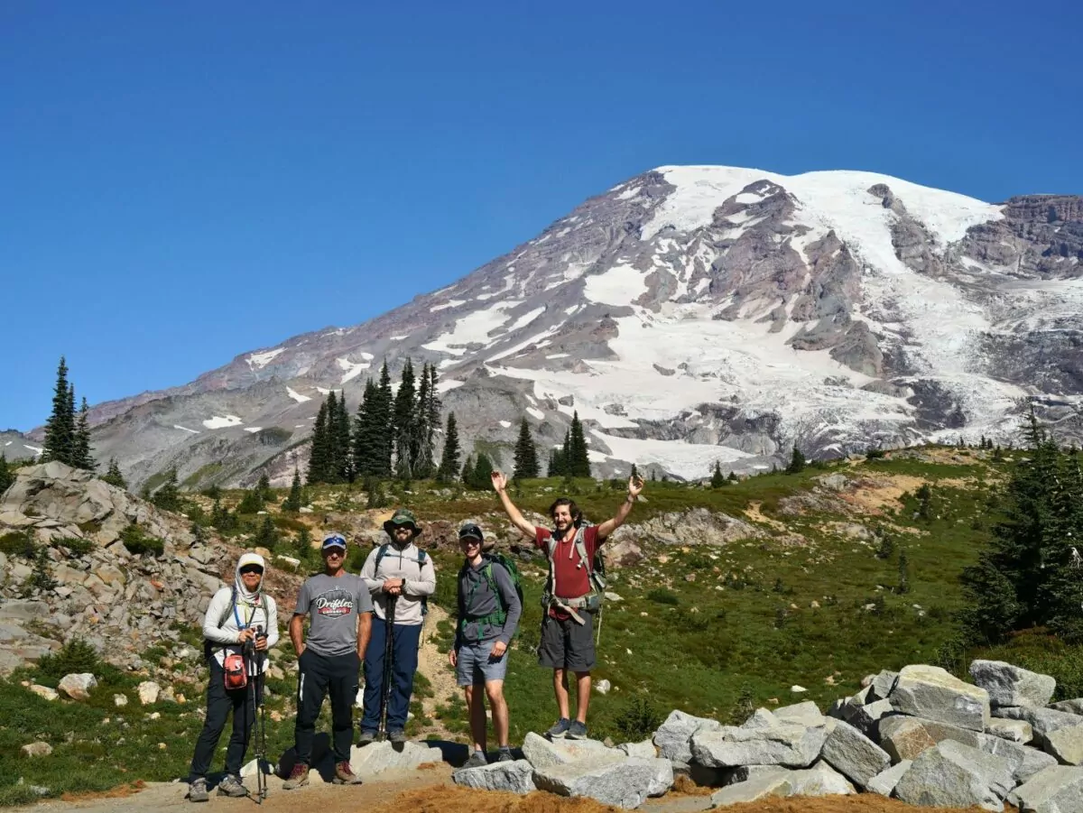 A group of hikers pose in front of Washington's Mount Rainier