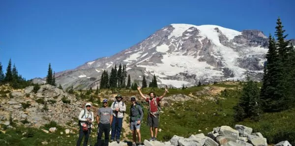 A group of hikers pose in front of Washington's Mount Rainier