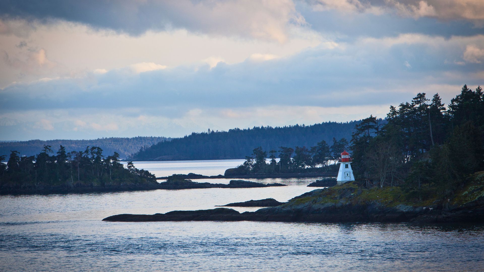 A lighthouse stands on the rocky shoreline of the san juan islands in Washington state