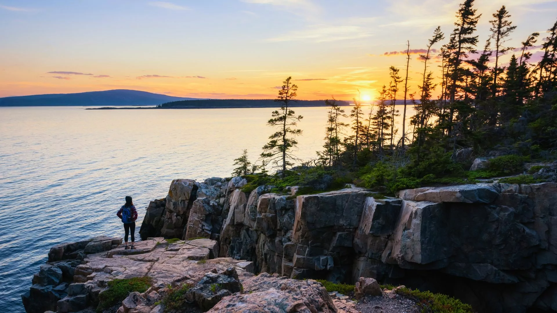 A person watches the sunset from the schoodic peninsula