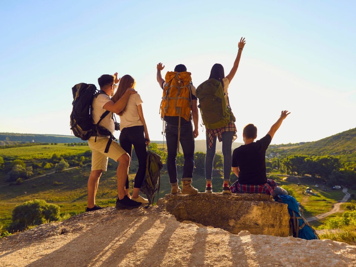 A group of hikers pose at a summit