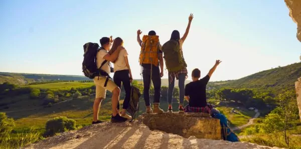 A group of hikers pose at a summit