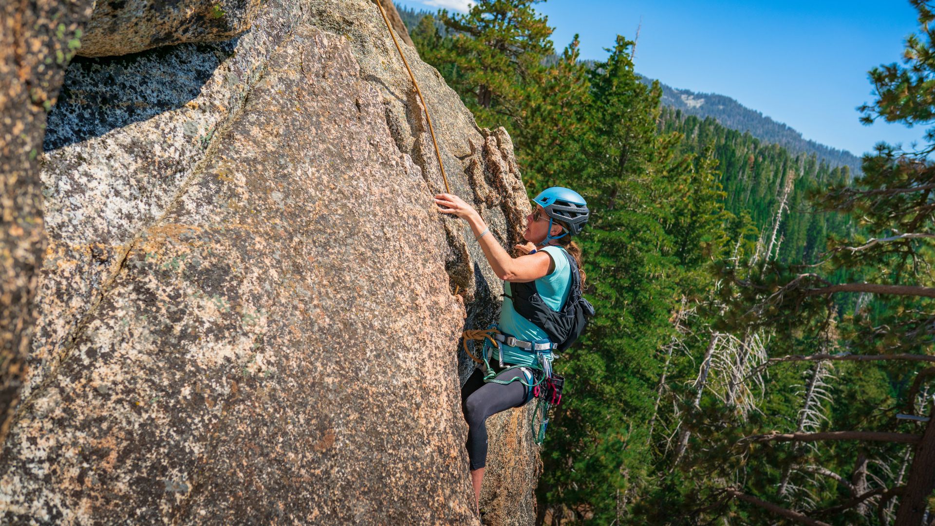 A woman rock climbs in the sierras
