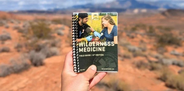 Wilderness medicine manual|An open medical text explains the steps of CPR|First aid kit